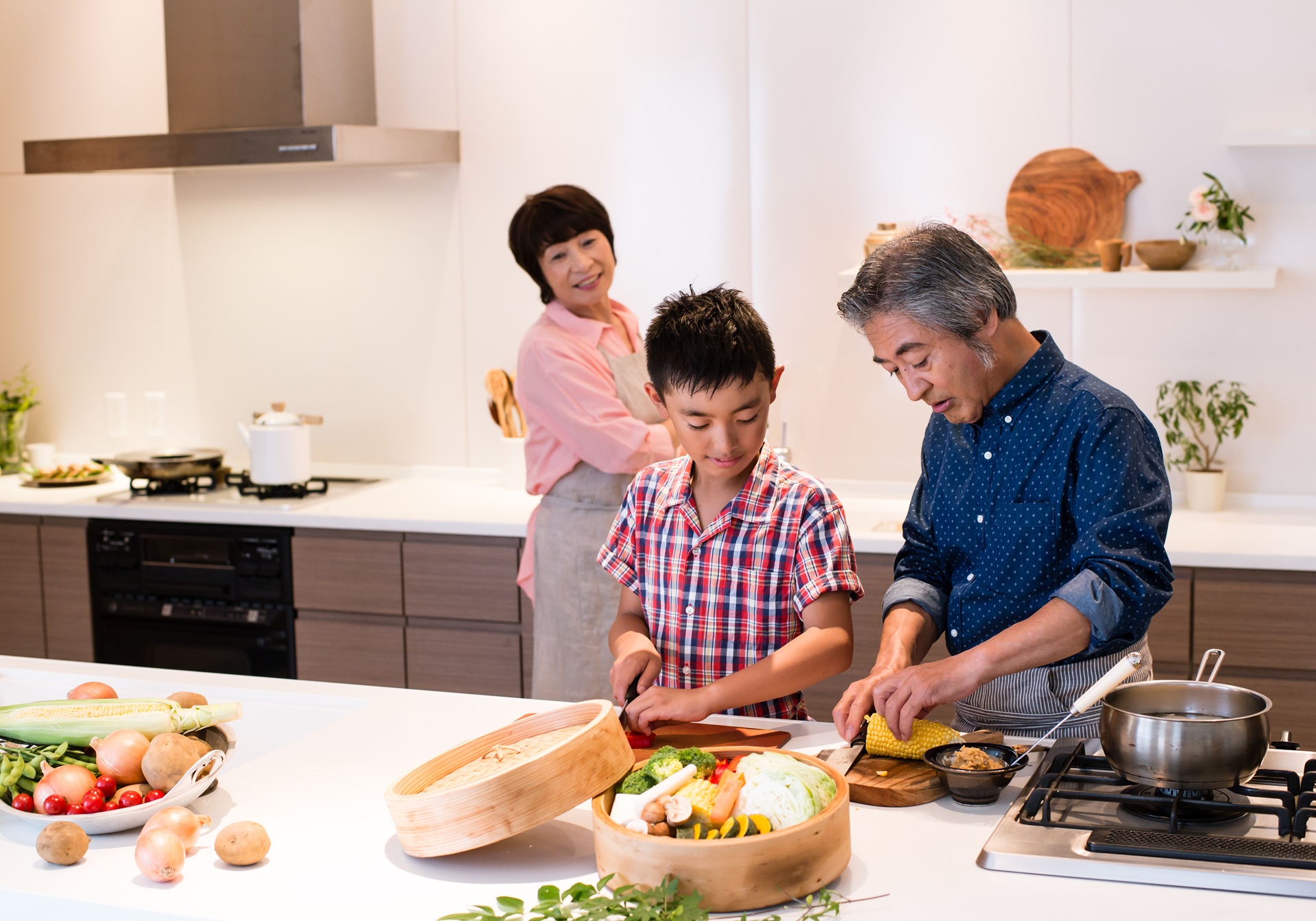 料理する祖父母と男の子
