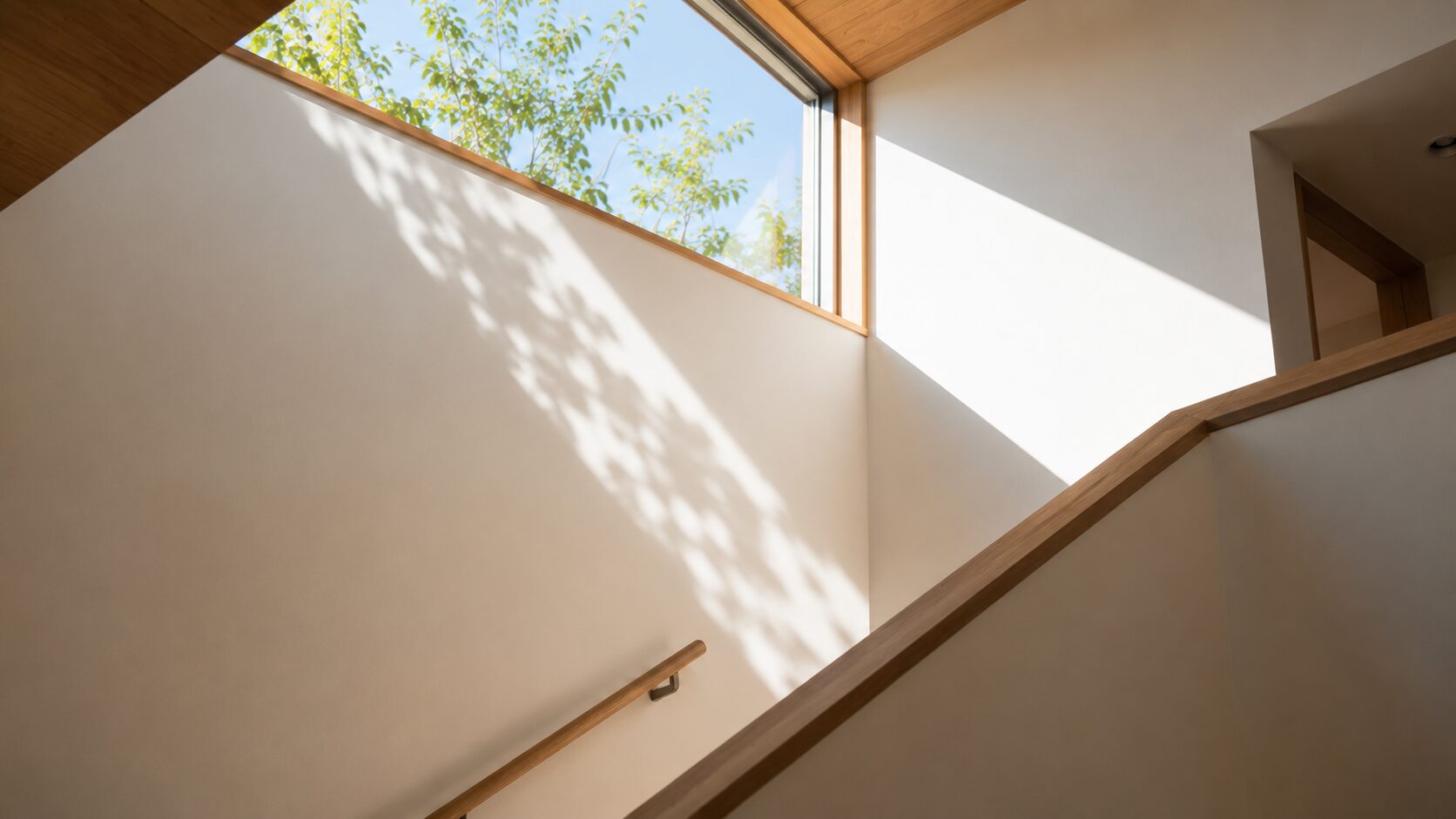 吹き抜け窓から差し込む美しい自然光と澄み切った室内空間の建築ディテール